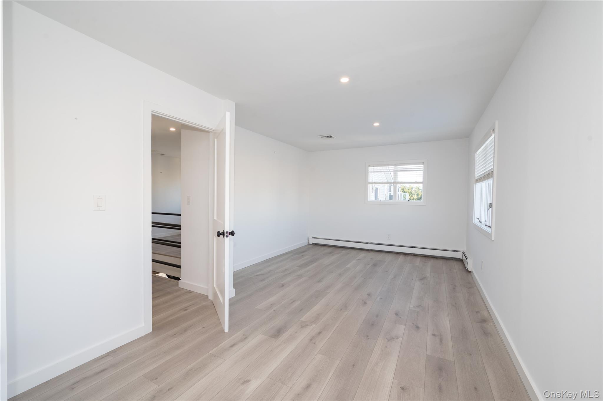 15 Roneck Court Shirley, NY 11967 - Photo 32 of 44 an empty room with wooden floor and window