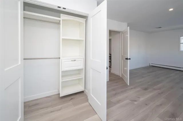 an empty room with wooden floor and window