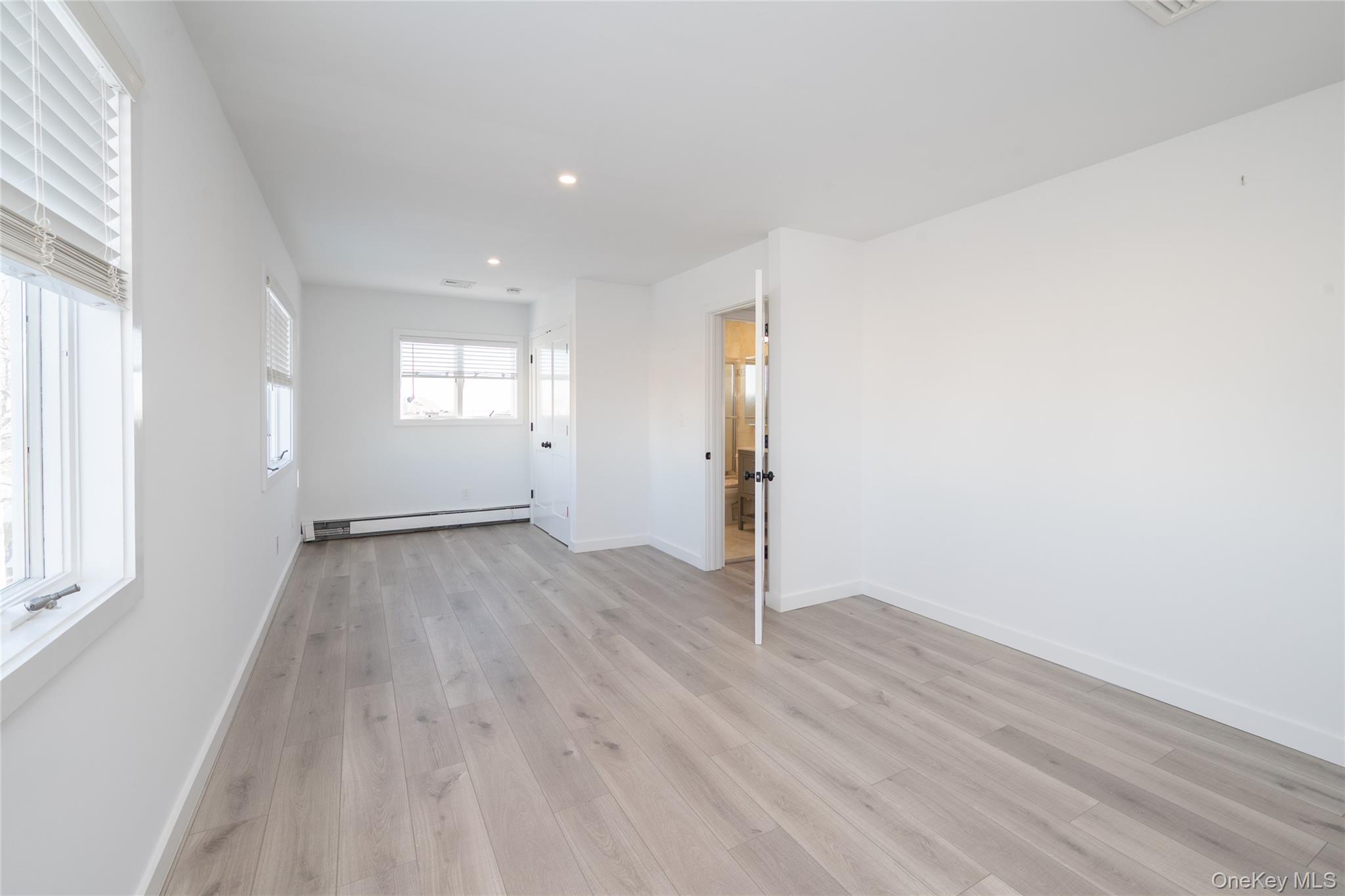 15 Roneck Court Shirley, NY 11967 - Photo 34 of 44 an empty room with wooden floor and windows