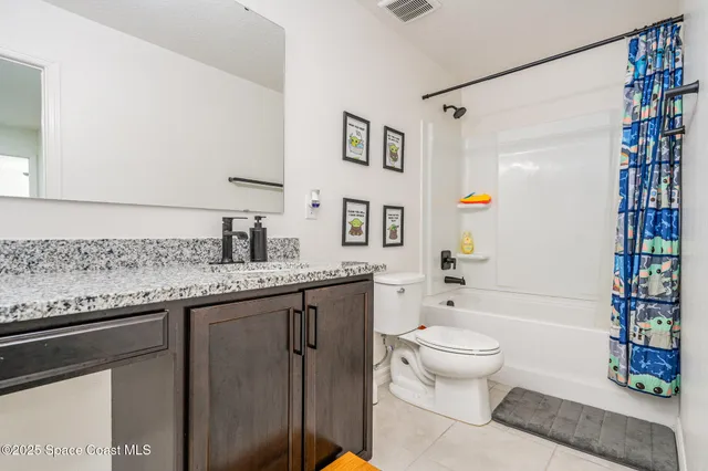 a spacious bathroom with a granite countertop sink toilet and shower