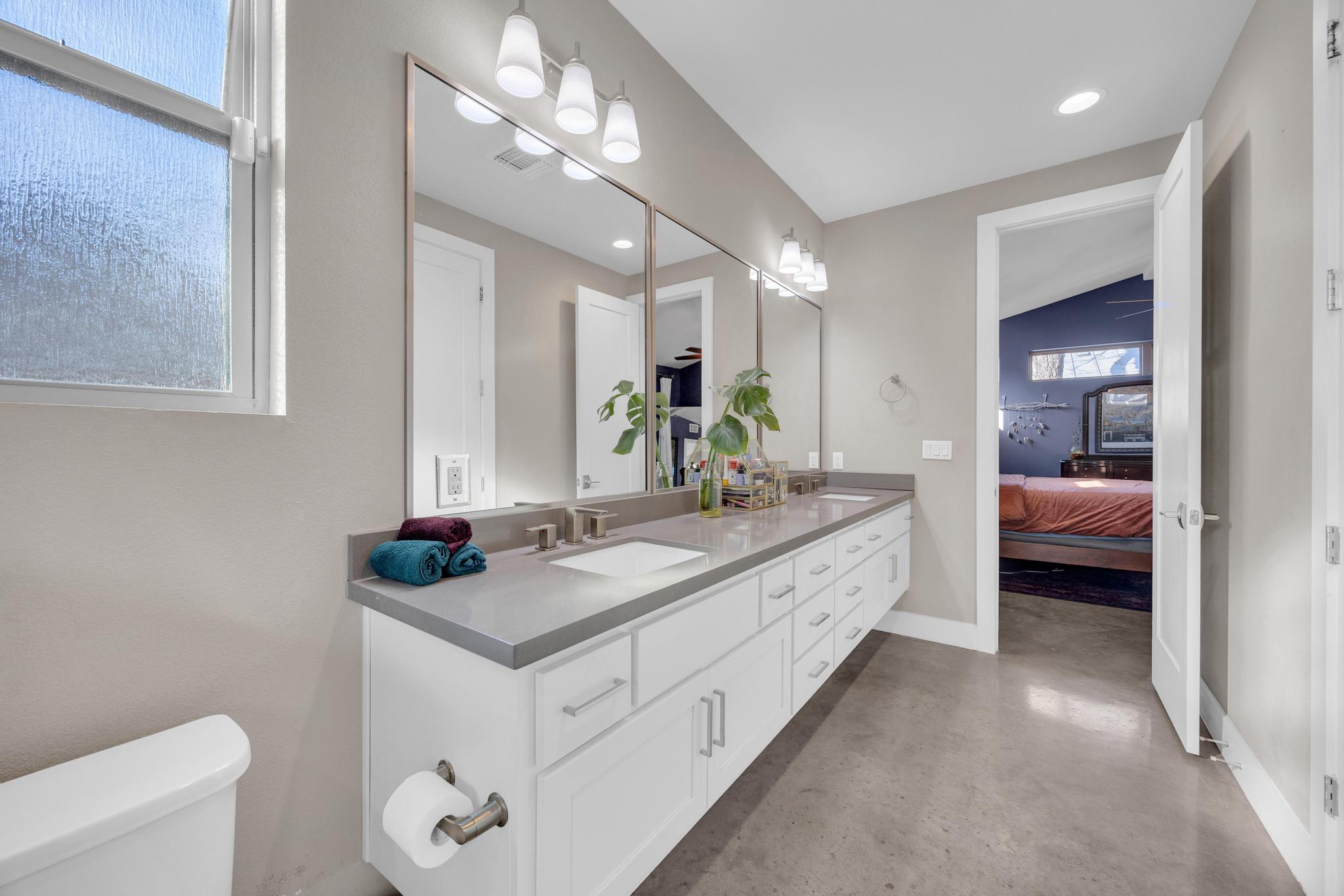 4404 Clarkson Avenue Austin, TX 78751 - Photo 15 of 35 a en suite bathroom with a granite countertop sink and a mirror