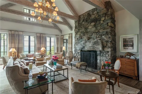 a living room with furniture a fireplace and a chandelier