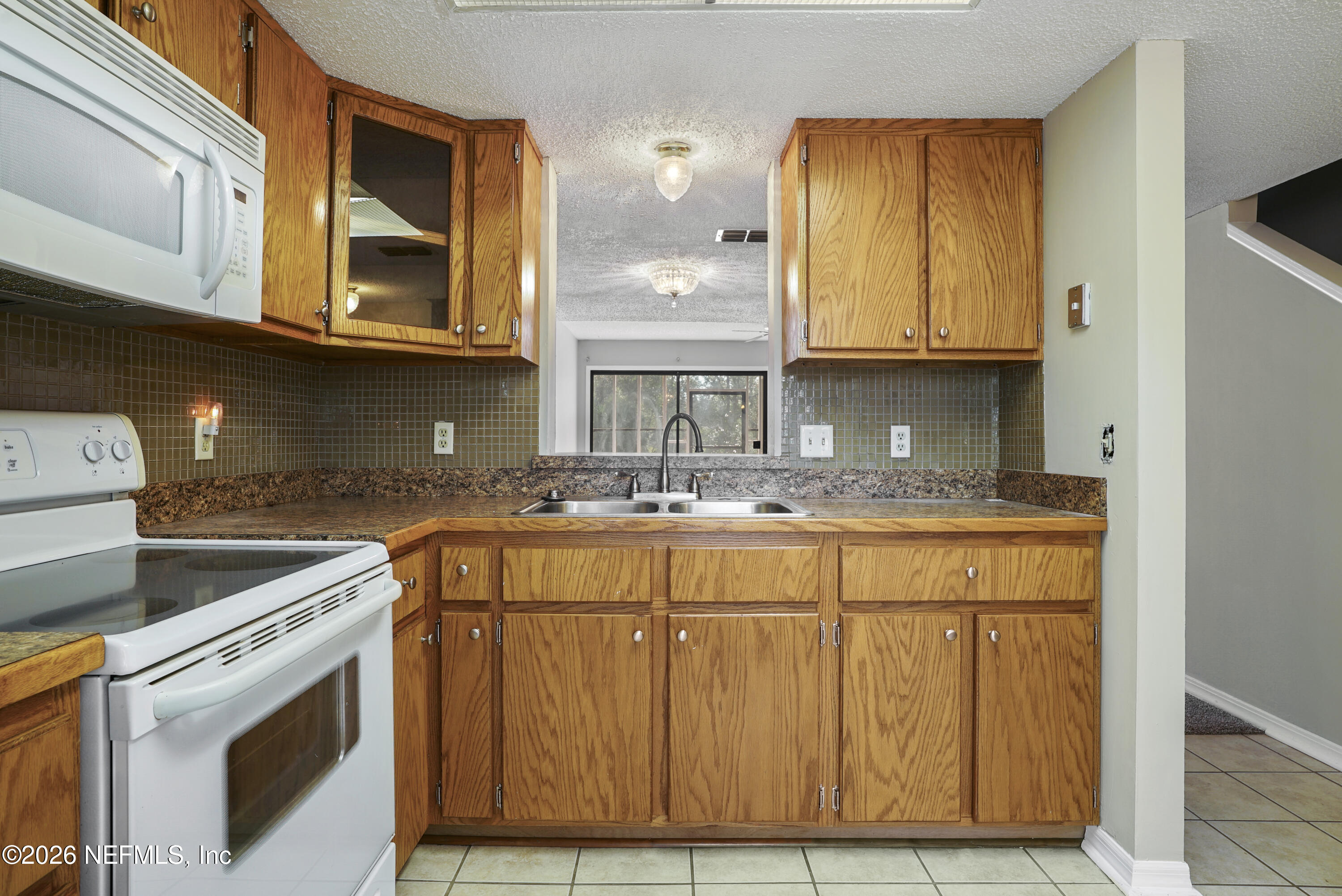 3517 Peeler Road, Unit 23 Jacksonville, FL 32277 - Photo 11 of 24 a kitchen with stainless steel appliances granite countertop a sink and cabinets with wooden floor