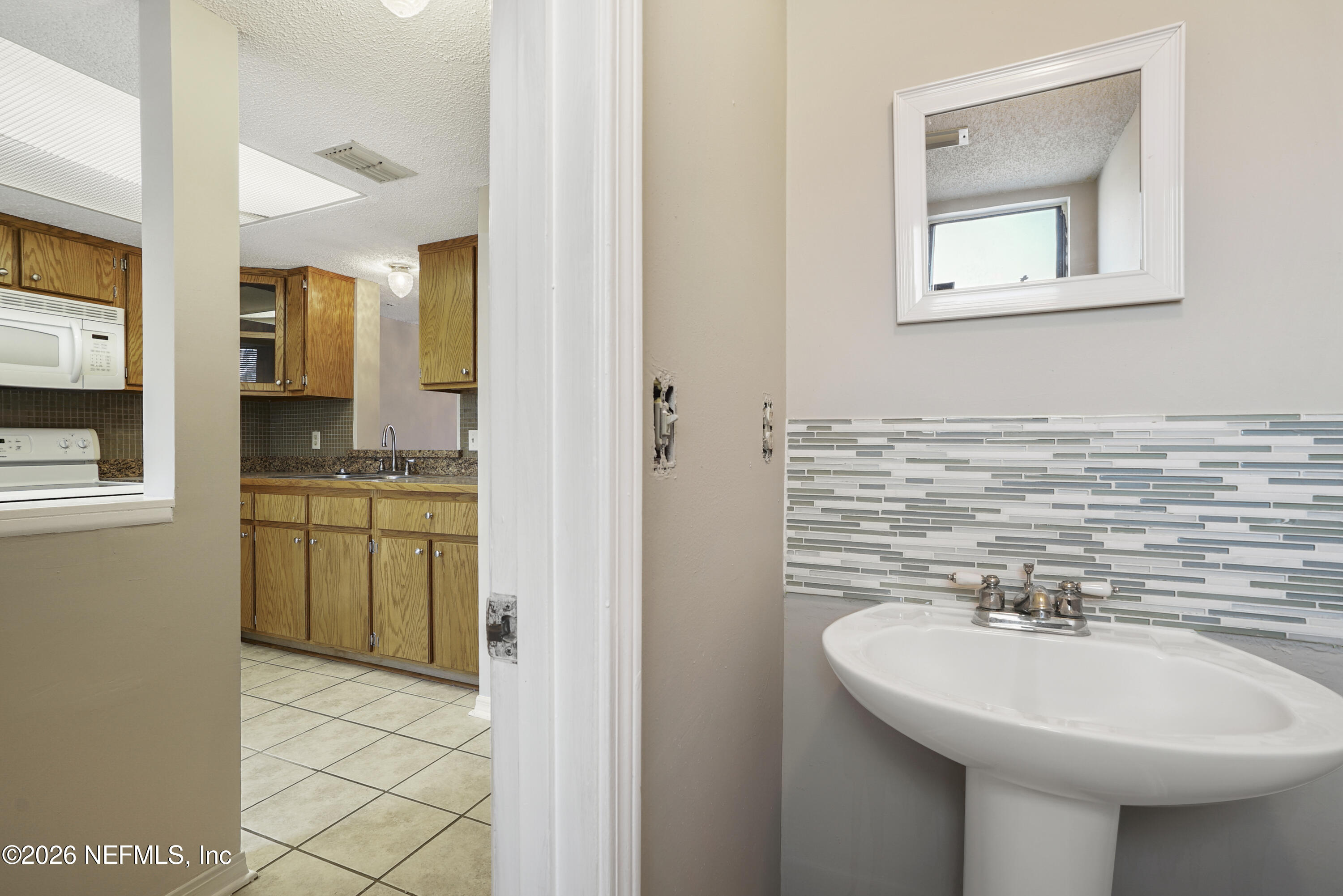 3517 Peeler Road, Unit 23 Jacksonville, FL 32277 - Photo 16 of 24 a bathroom with a sink a vanity and a mirror