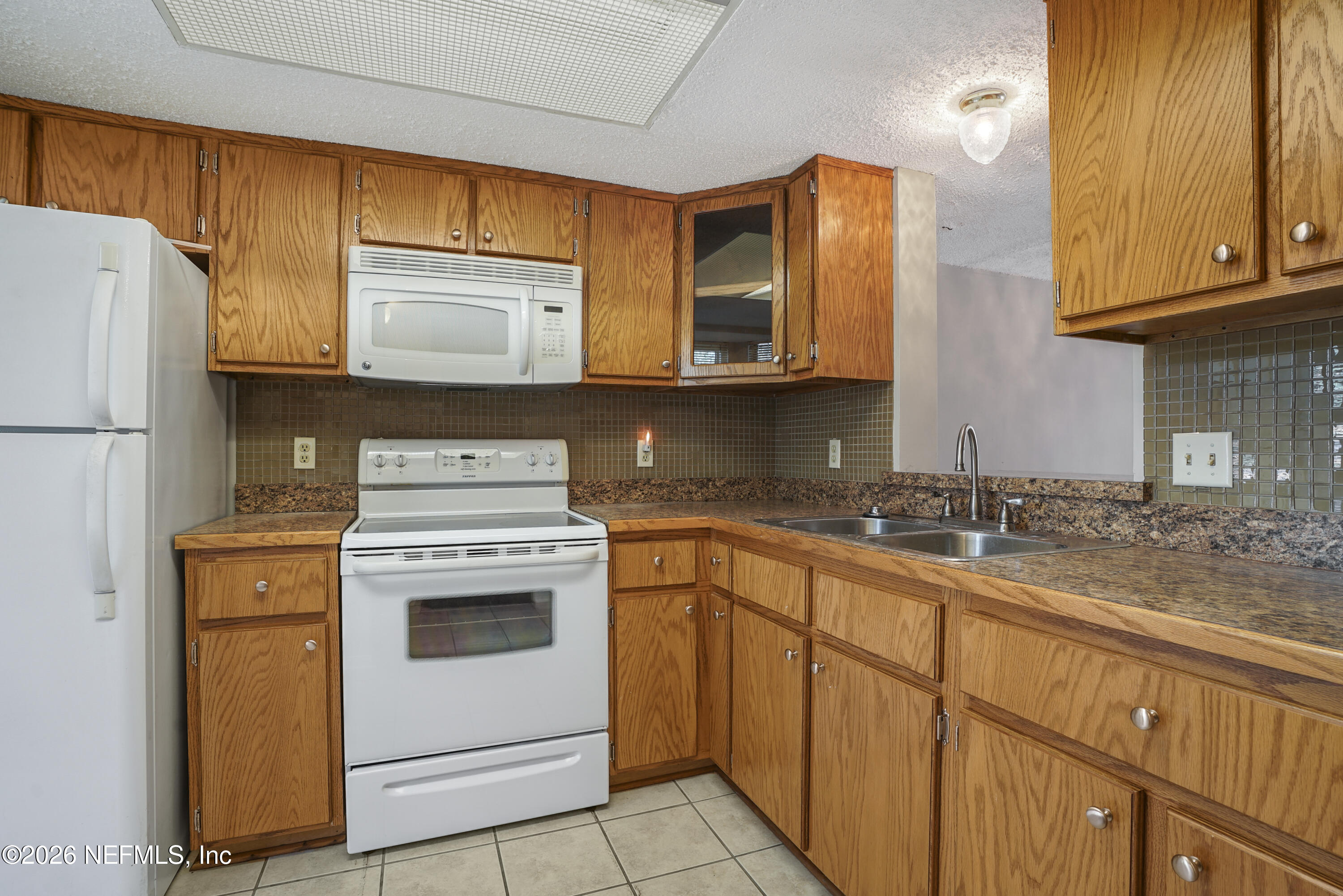 3517 Peeler Road, Unit 23 Jacksonville, FL 32277 - Photo 2 of 24 a kitchen with stainless steel appliances granite countertop a sink stove and refrigerator