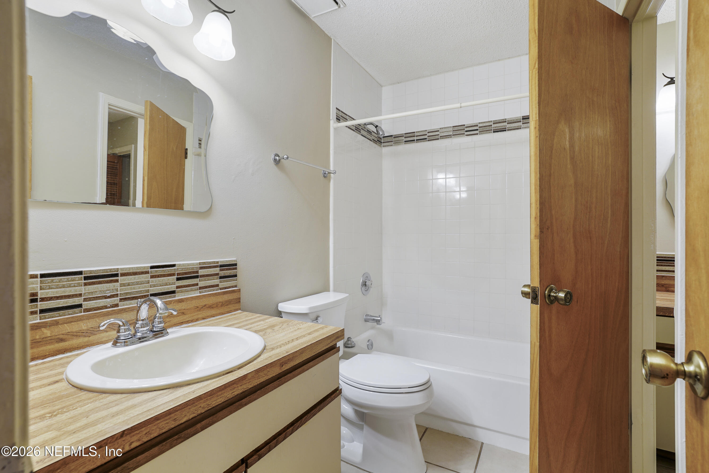 3517 Peeler Road, Unit 23 Jacksonville, FL 32277 - Photo 4 of 24 a bathroom with a granite countertop sink toilet a mirror and shower