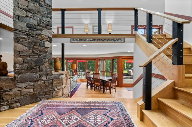 a open kitchen with stainless steel appliances granite countertop a stove a refrigerator a table and chairs with wooden floor