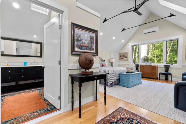 a living room with furniture a rug kitchen view and large windows