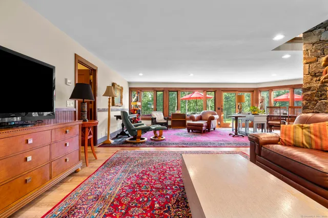 a living room with a mirror and a wooden floor