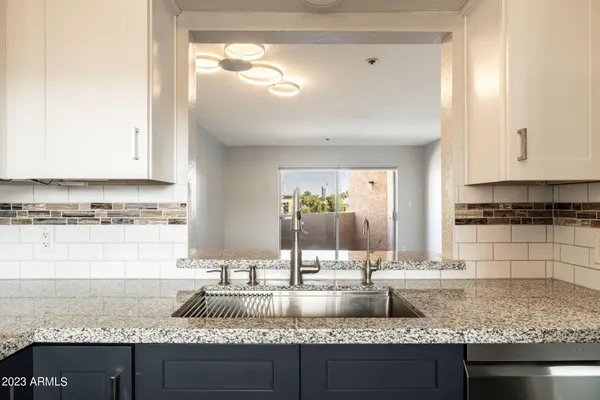 a kitchen with granite countertop a sink a stove and cabinets
