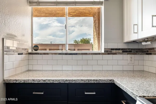 a bathroom with a granite countertop sink and a window