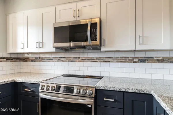 a kitchen with granite countertop a stove microwave and sink