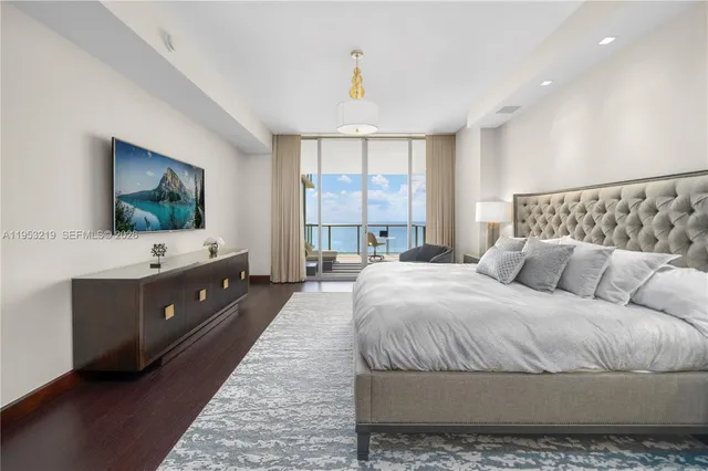 a spacious bedroom with a large bed and a flat screen tv