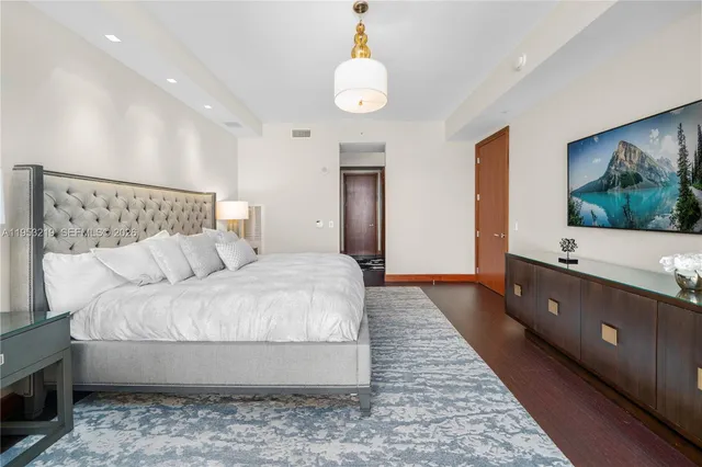 a spacious bedroom with a bed and a flat screen tv