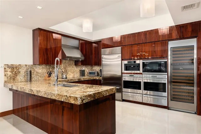 a kitchen with stainless steel appliances a sink and a refrigerator