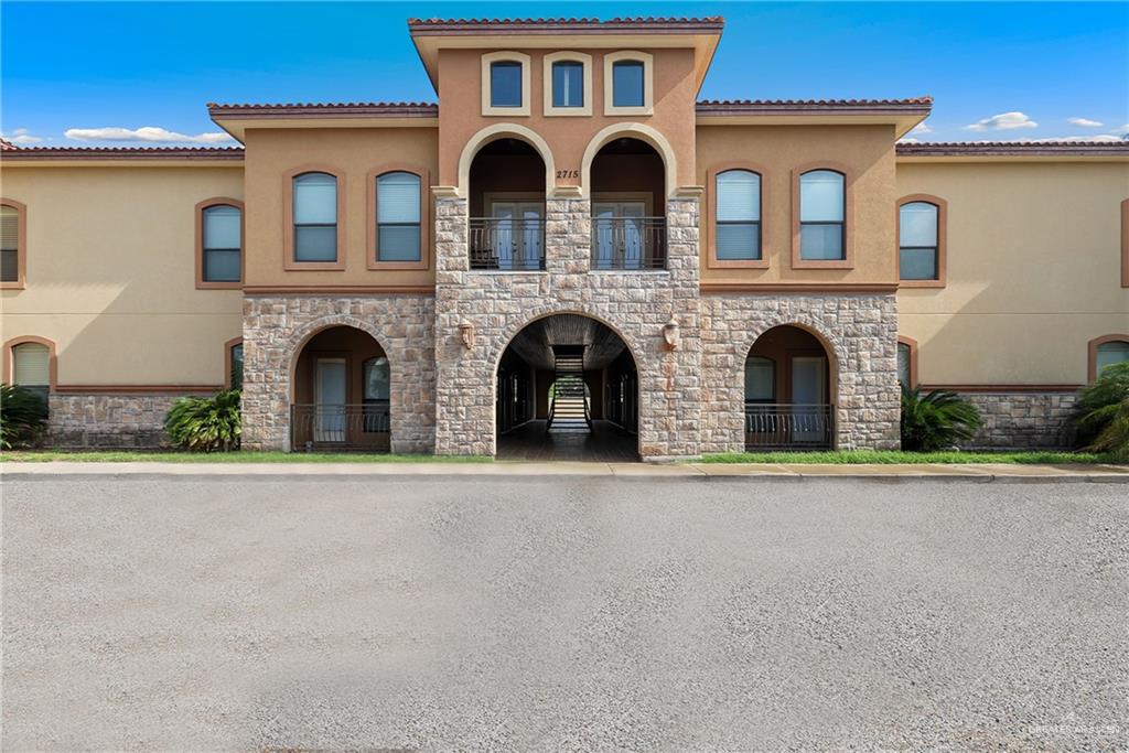 a view of white building with large windows and a yard