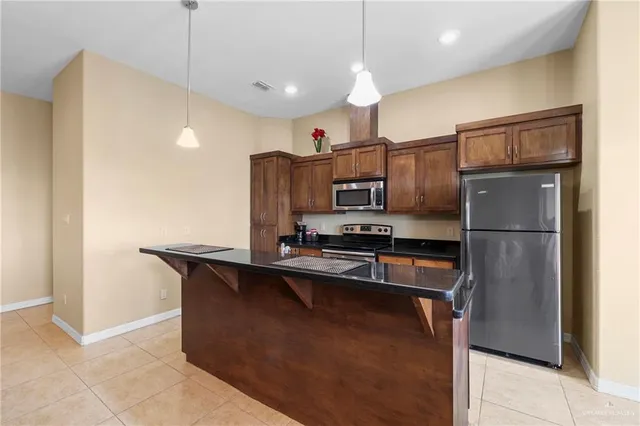 a kitchen with kitchen island a counter top space stainless steel appliances and cabinets