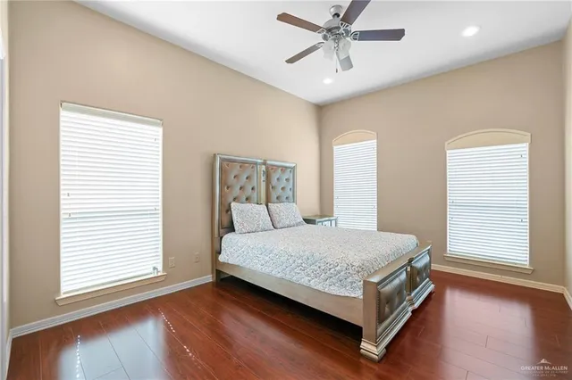 a bed sitting in a spacious bedroom next to a window