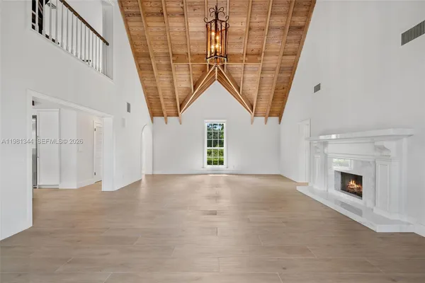 a view of a big room with wooden floor and windows
