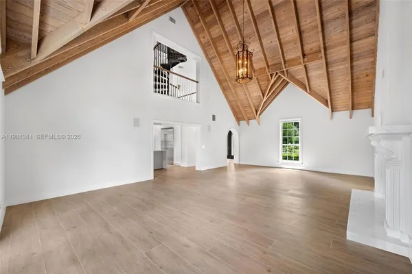 a view of a livingroom with a chandelier and wooden floor