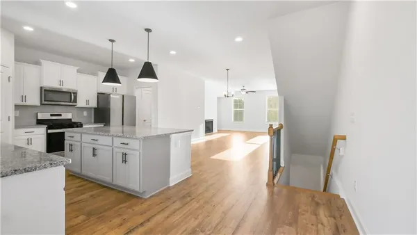 a large kitchen with white cabinets and stainless steel appliances
