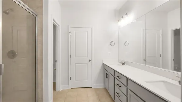 a spacious bathroom with a double vanity sink a mirror and a shower