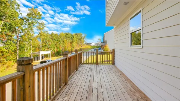 a pathway of a house with potted plants and a bench
