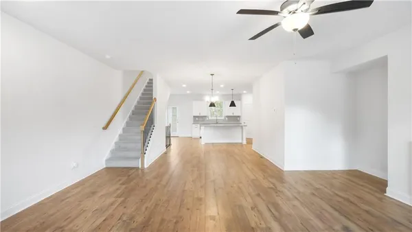 a view of a hallway with wooden floor and staircase