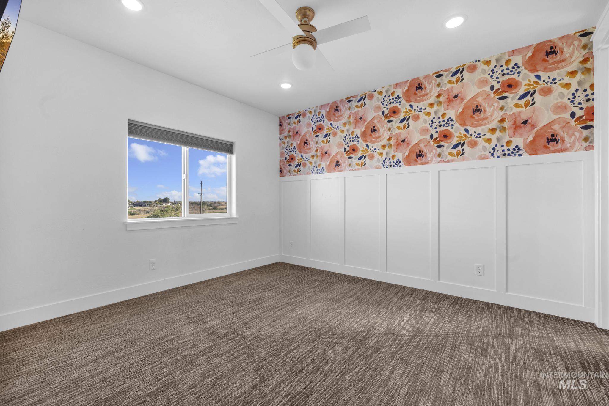 4280 Rim Vista Road Filer, ID 83328 - Photo 38 of 50 Recessed lighting, ceiling fan, accent wall with floral wallpaper, board and batten paneling, and patterned carpet flooring