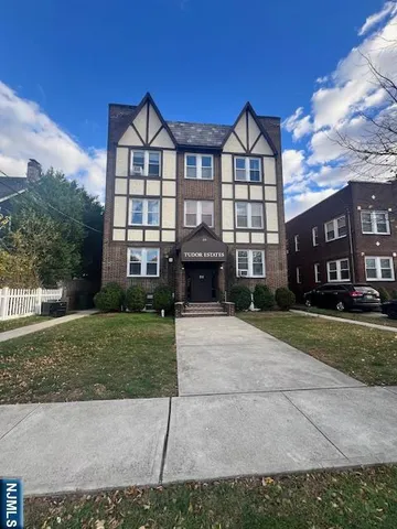 a front view of a residential apartment building with a yard
