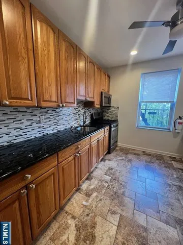 a kitchen with stainless steel appliances granite countertop a stove a sink and a microwave