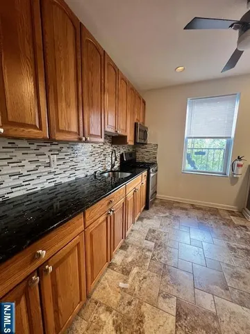 a kitchen with stainless steel appliances granite countertop a sink stove and cabinets
