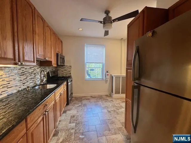 a kitchen with granite countertop a refrigerator and a sink