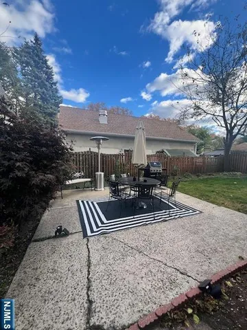 a view of a patio with couches and table and chairs with wooden fence