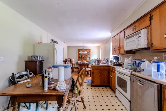 a kitchen with a sink appliances cabinets and dining table