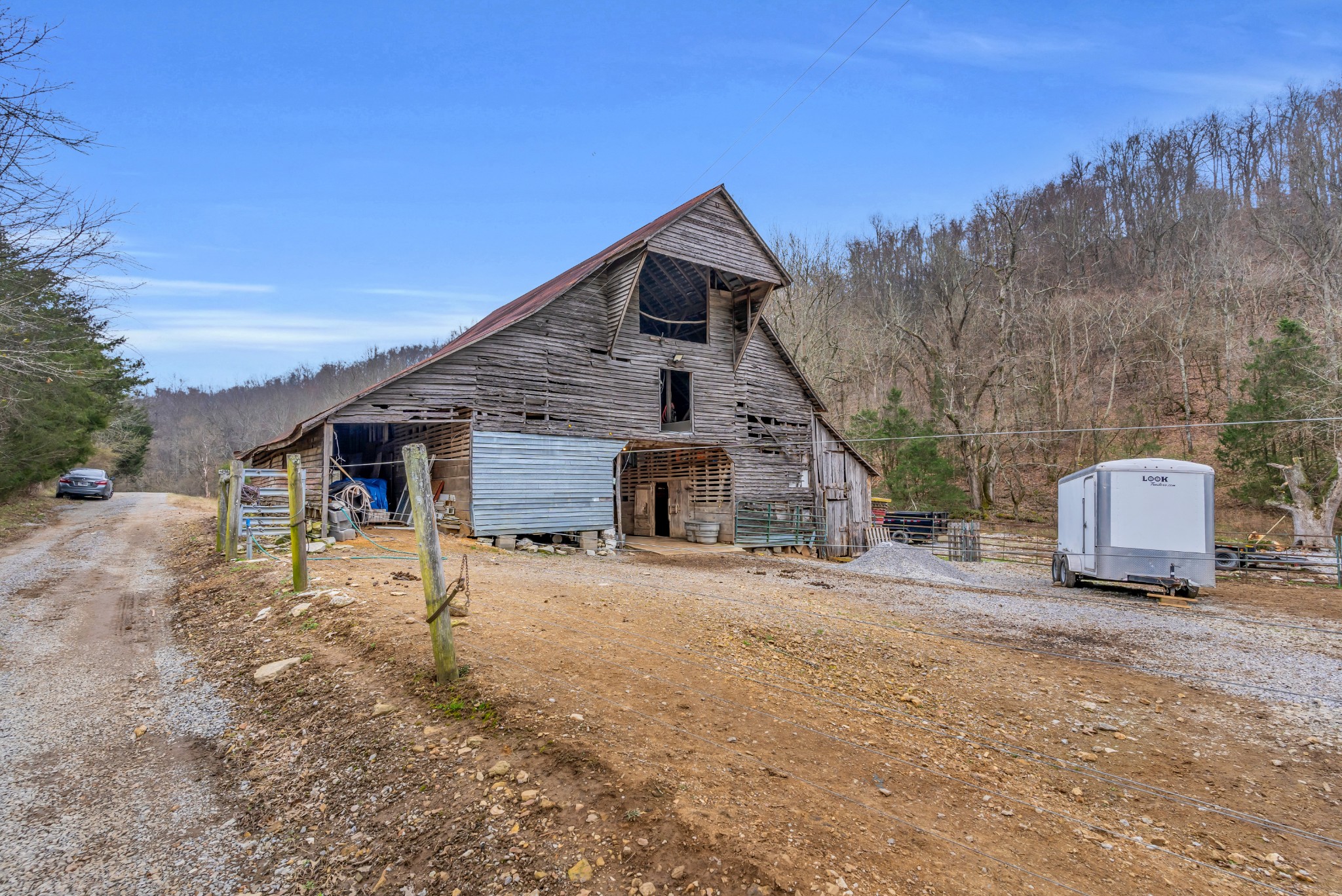 3039 Pigg Hollow Road Petersburg, TN 37144 - Photo 34 of 38 a dirt road with an house wooden fence and trees in the background