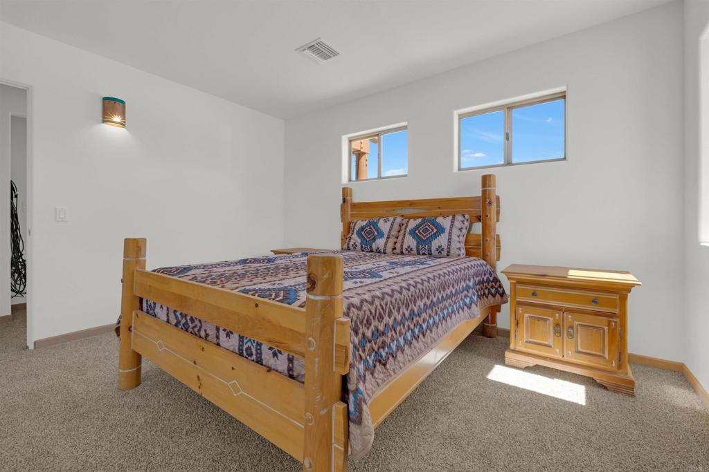 6226 Split Mountain Road Borrego Springs, CA 92004 - Photo 21 of 57 a bedroom with a bed and a painting on the wall