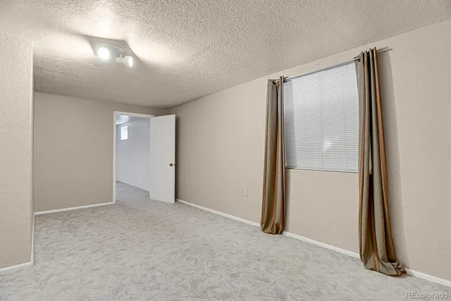 an empty room with closet and mirror