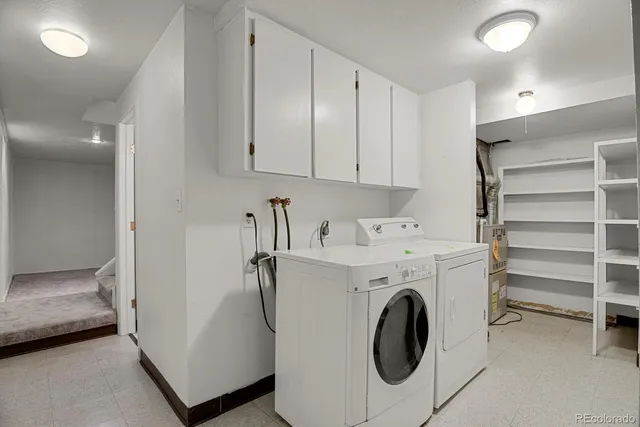 a utility room with cabinets washer and dryer