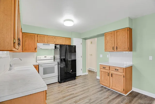 a kitchen with a refrigerator and a stove top oven