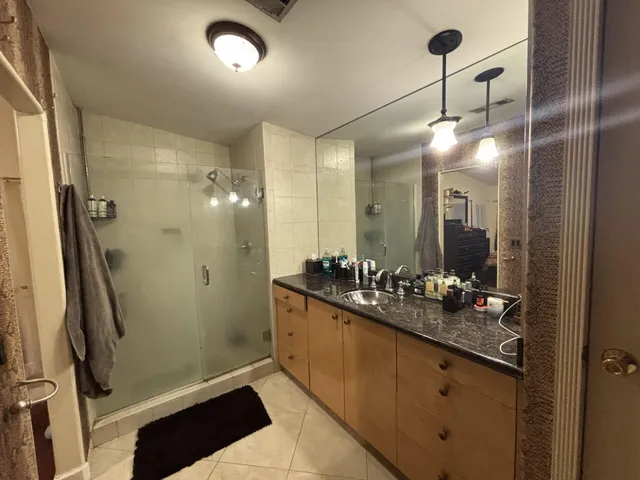 a bathroom with a double vanity sink mirror and shower