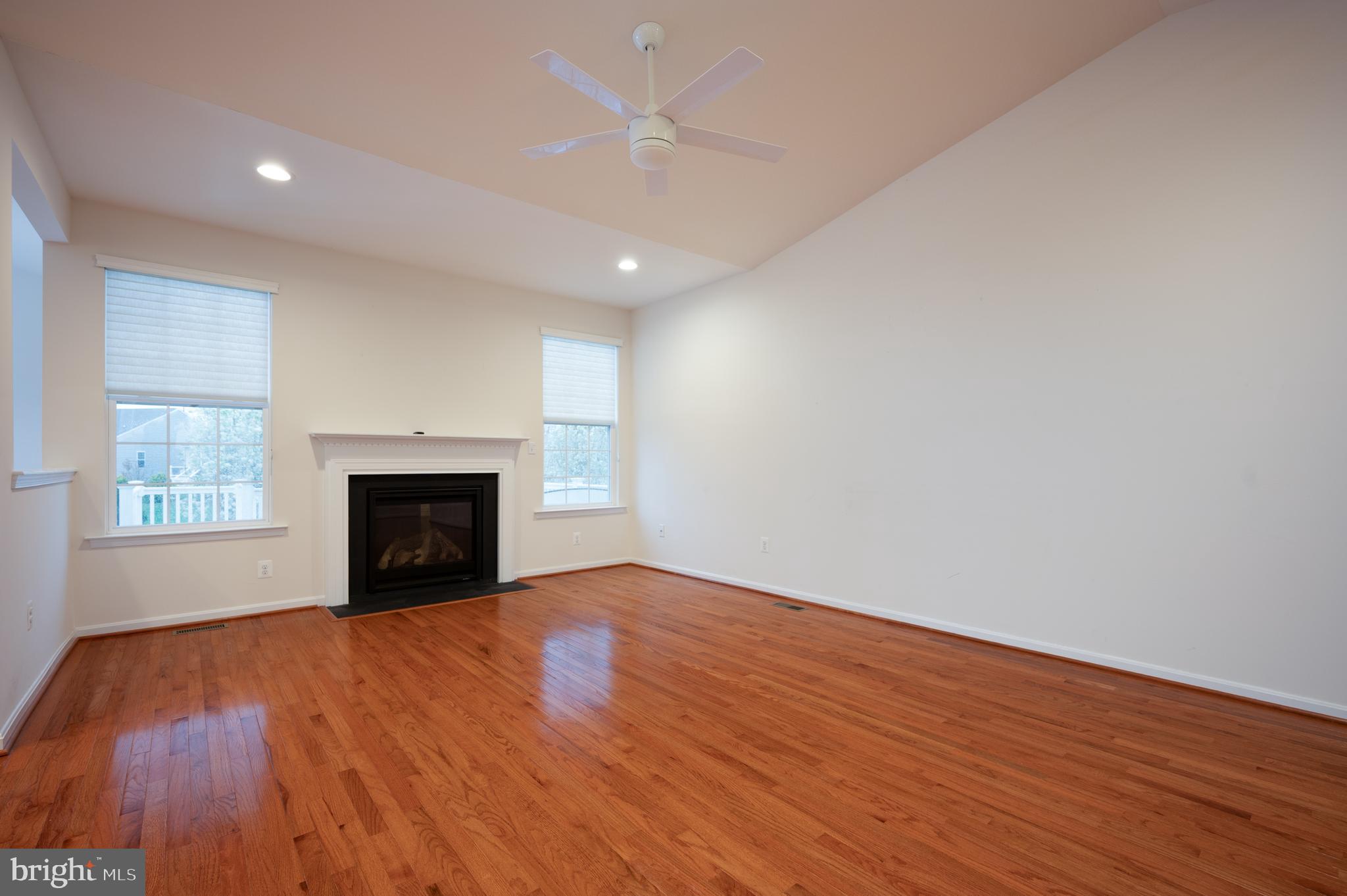 173 Silver Maple Road Middletown, DE 19709 - Photo 12 of 36 an empty room with wooden floor fireplace and windows