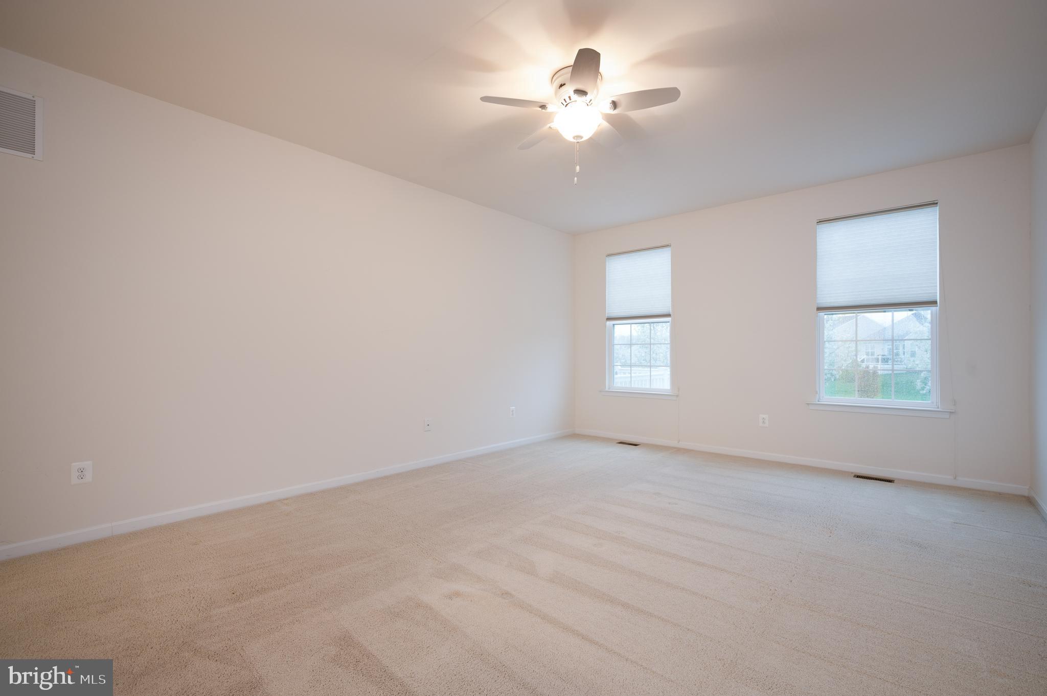 173 Silver Maple Road Middletown, DE 19709 - Photo 18 of 36 an empty room with a chandelier fan and windows