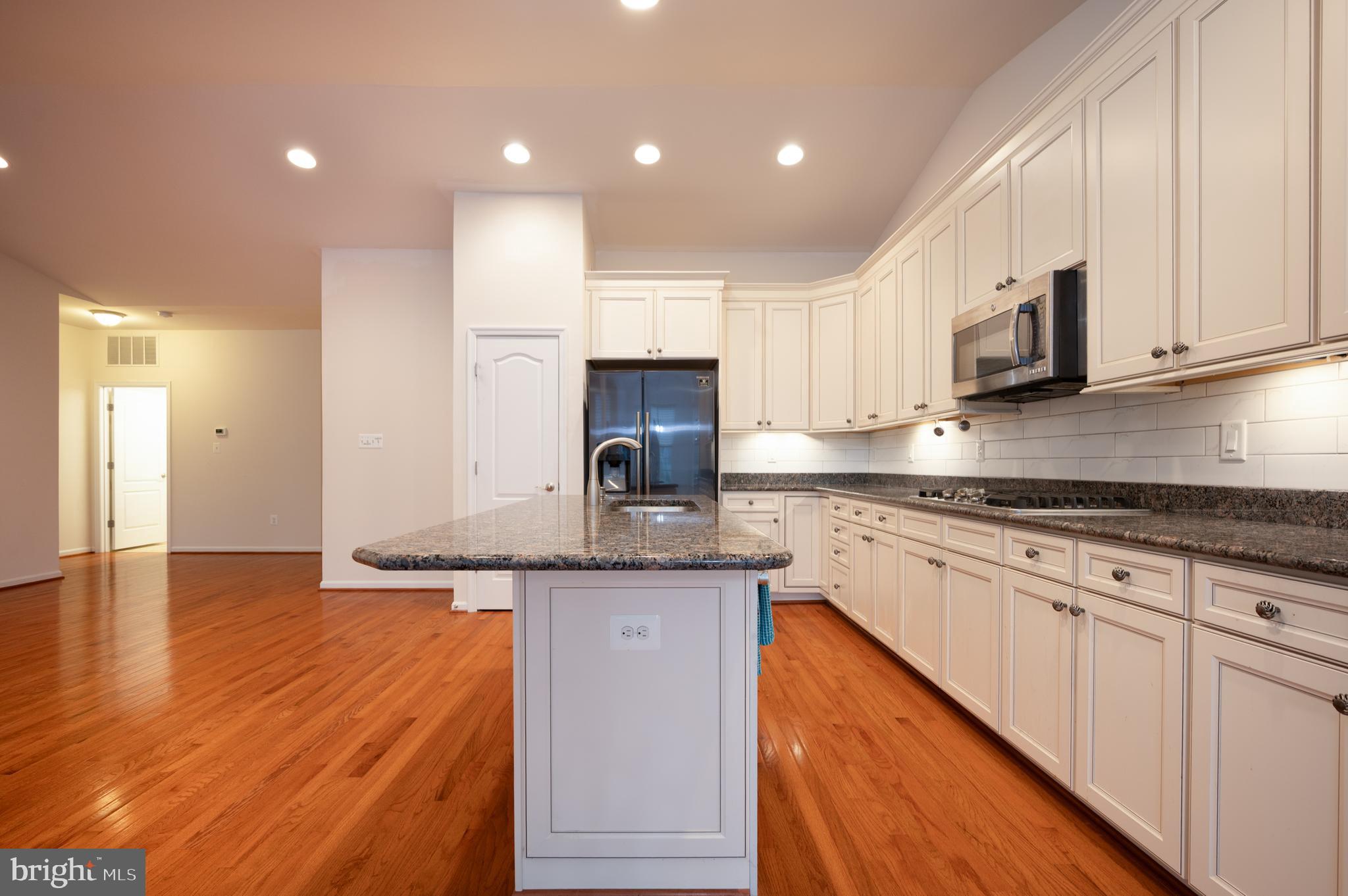 173 Silver Maple Road Middletown, DE 19709 - Photo 4 of 36 a kitchen with stainless steel appliances granite countertop a sink a stove a microwave a sink and cabinets