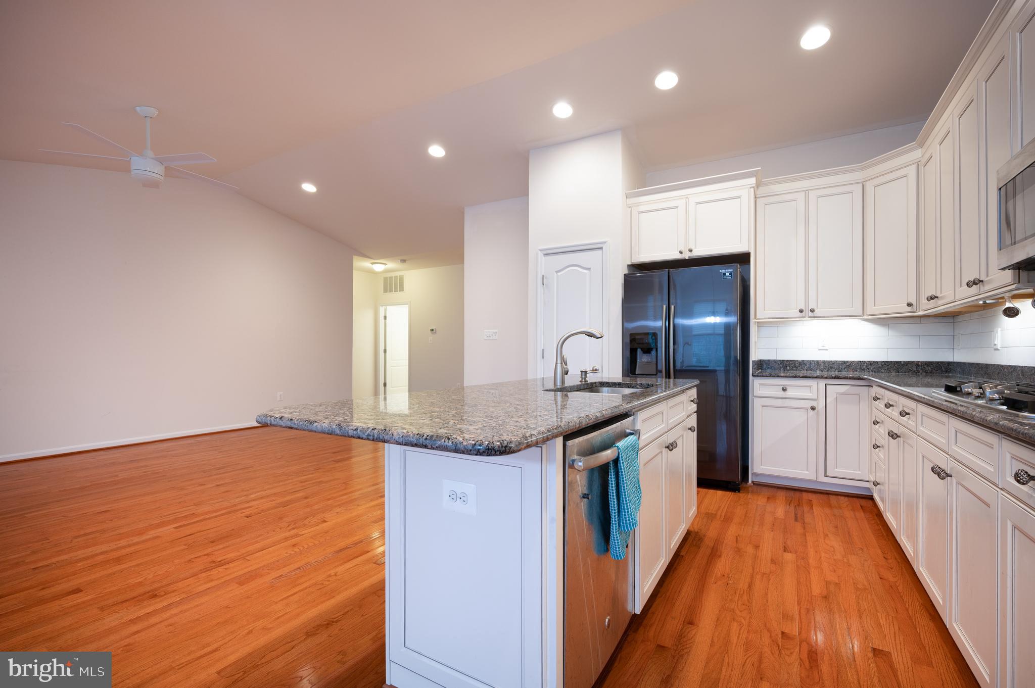 173 Silver Maple Road Middletown, DE 19709 - Photo 7 of 36 a kitchen with granite countertop kitchen island wooden floor center island and stainless steel appliances