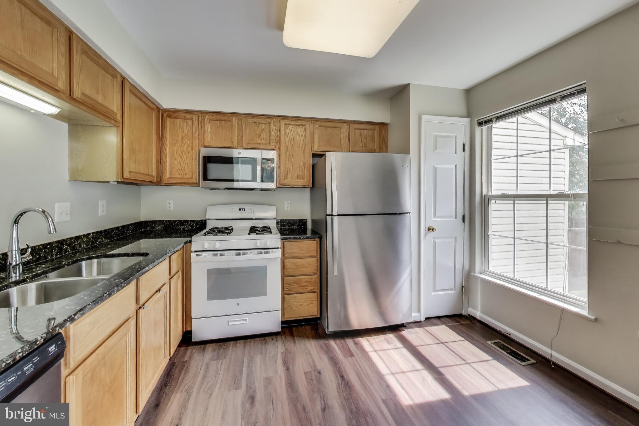 13504 Hayworth Drive Rockville, MD 20854 - Photo 2 of 31 a kitchen with a refrigerator a stove a microwave and cabinets