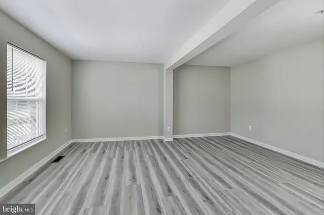 wooden floor in an empty room with a window