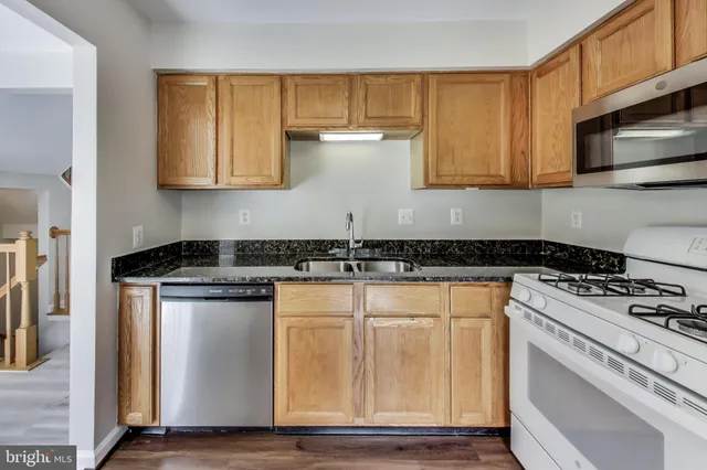 a white stove top oven sitting inside of a kitchen