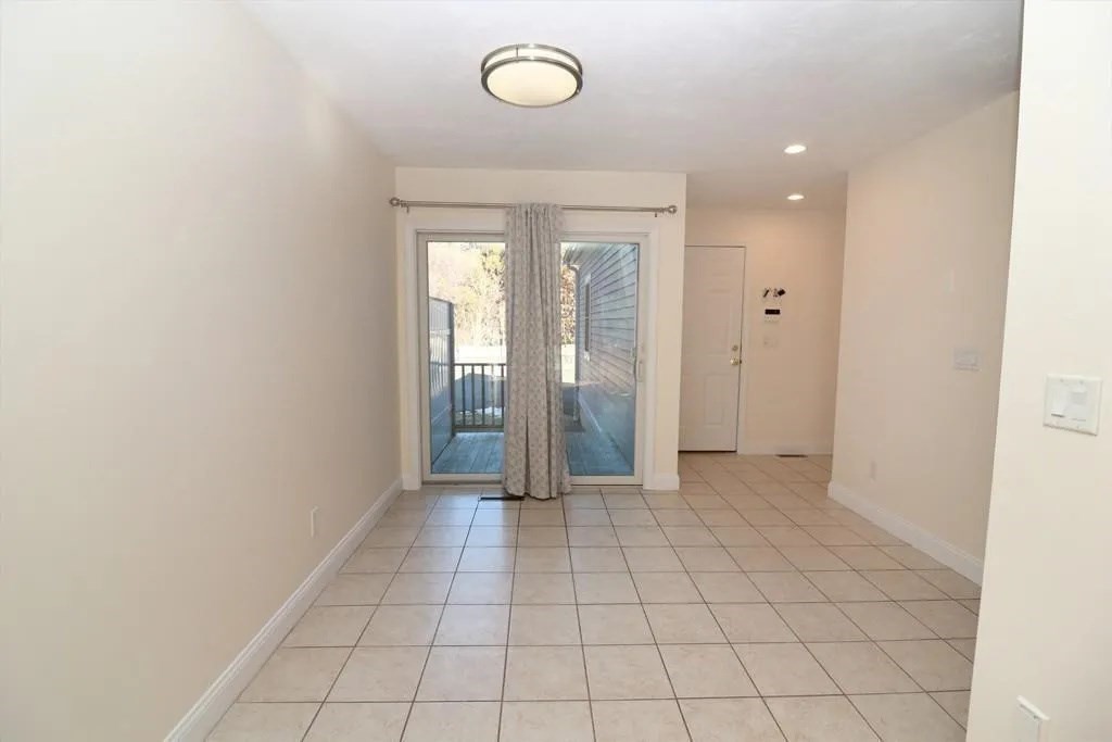 132 Howe Street, Unit B Natick, MA 01760 - Photo 12 of 32 an empty room with white cabinet and mirror