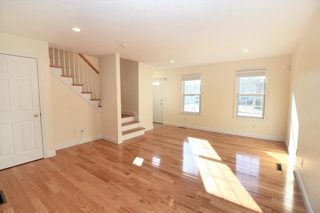 132 Howe Street, Unit B Natick, MA 01760 - Photo 13 of 32 a view of an empty room with wooden floor and a window
